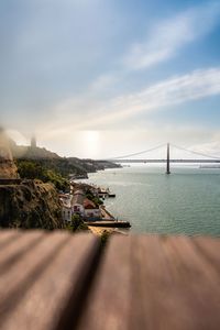 Scenic view of suspension bridge over sea against sky