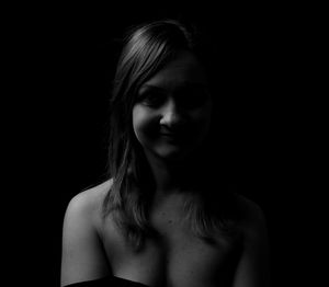 Portrait of a beautiful young woman over black background