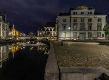 Bridge over river by houses at night