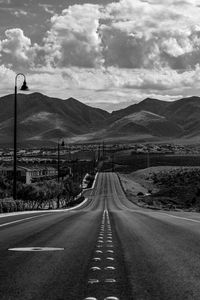 Empty road against mountains and sky