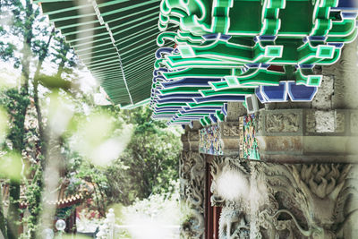 Low angle view of multi colored umbrellas hanging on building