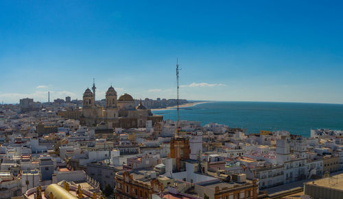 High angle view of cityscape by sea against sky