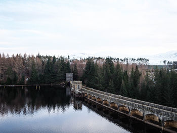 Bridge over river against sky during winter