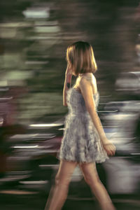 Rear view of woman standing against blurred background