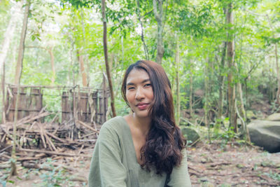 Portrait of smiling young woman in forest