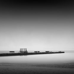 Pier at beach against sky