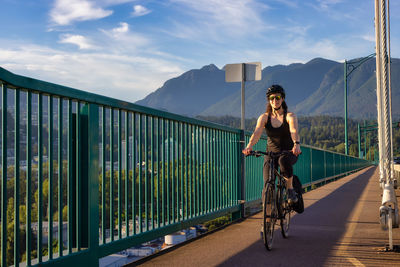 Man riding bicycle on mountain against sky