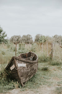 Abandoned boat on field against clear sky