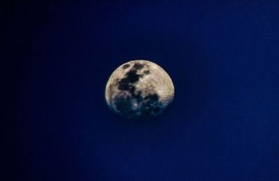 Low angle view of moon against blue sky at night