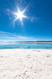 Scenic view of sea against blue sky on sunny day