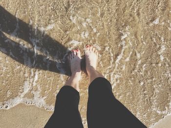 Low section of woman standing on beach