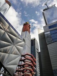 Low angle view of modern buildings against cloudy sky