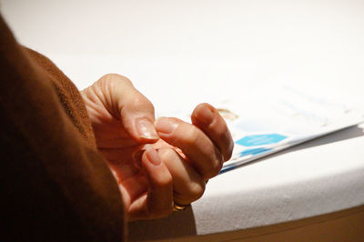 Close-up of hand by table