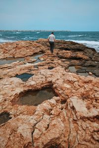 Rear view of man standing on rock