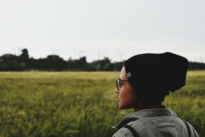 Portrait of woman standing on field against sky