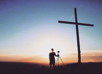 Silhouette man standing on field against sky