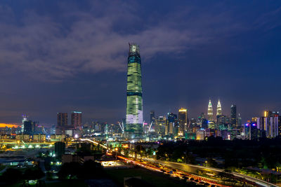 Illuminated buildings in city against sky at night