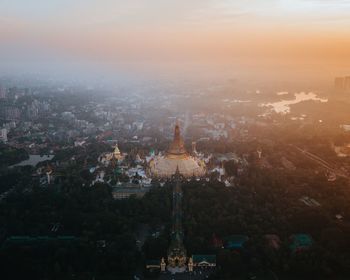 Statue in city at sunset