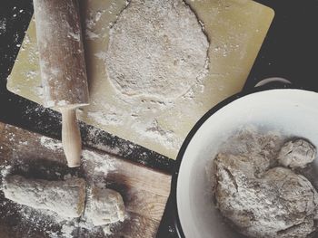 Directly above shot of rolling pin with dough and cutting board