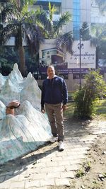 Man standing on footpath amidst plants