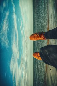 Low section of man standing by sea