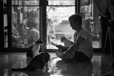 Man sitting with cats at home