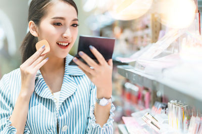 Smiling young woman using mobile phone