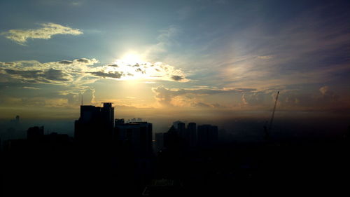 Silhouette buildings against sky during sunset