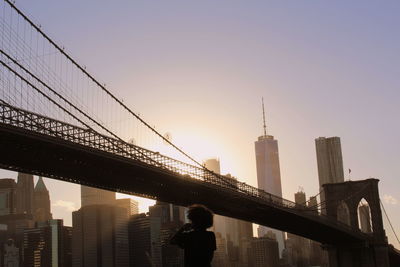 Low angle view of bridge and buildings against sky