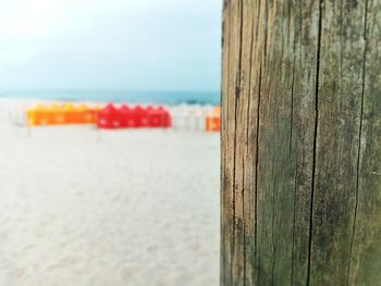 Close-up of wooden post by sea against sky