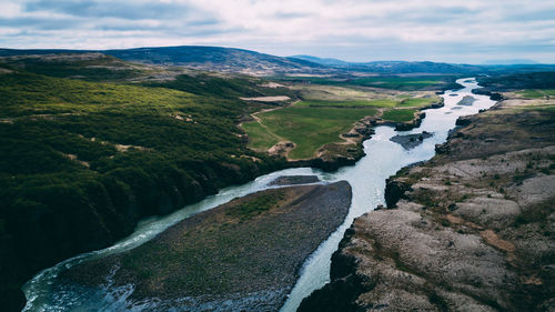 Scenic view of river amidst mountains against sky