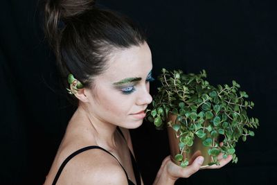 Close-up of beautiful woman against black background