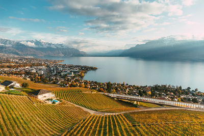 High angle view of farm and lake against sky