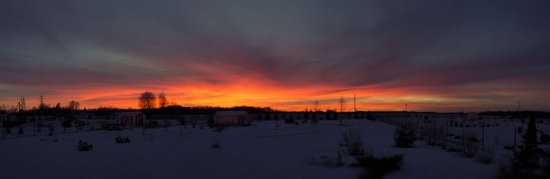 Panoramic view of snow covered landscape against sky during sunset