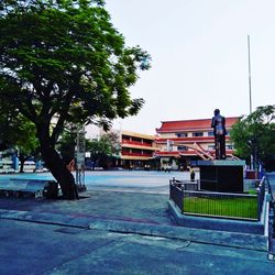 Empty road by buildings against sky in city