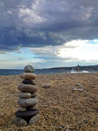 Scenic view of beach against cloudy sky