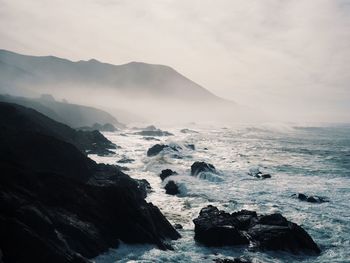 Scenic view of sea and mountains against sky