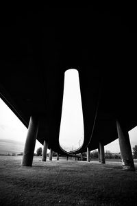 Low angle view of bridge over field against clear sky