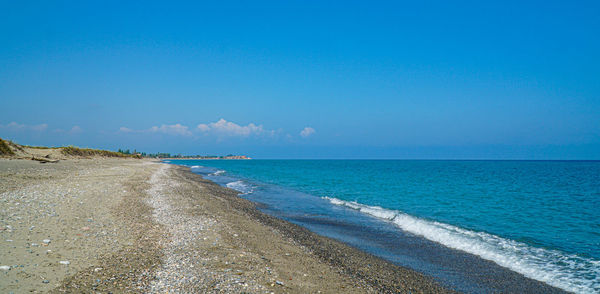 Scenic view of beach against blue sky