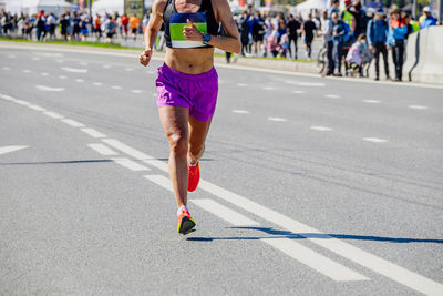 Low section of woman walking on road