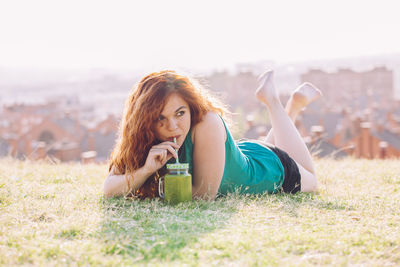 Portrait of young woman lying on land