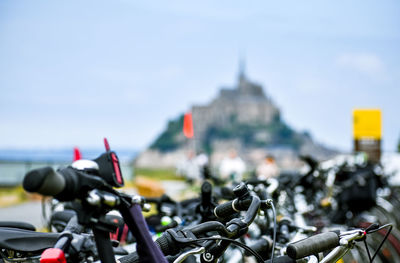 Detail of parked bicycles, with defocused silhouette of mont saint michel, france