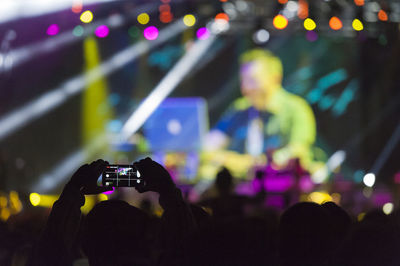 Person photographing with smart phone during sea dance festival