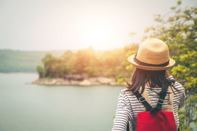 Rear view of woman wearing hat standing against sky