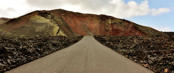 Road amidst mountains against sky