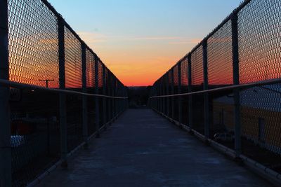 Walkway against sky during sunset