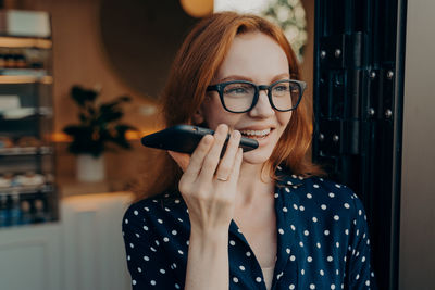 Young woman using mobile phone at home