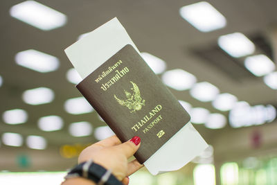 Close-up of woman hand holding passport at airport