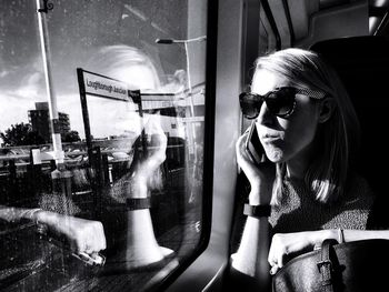 Young woman looking through window