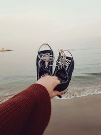 Man holding umbrella on beach